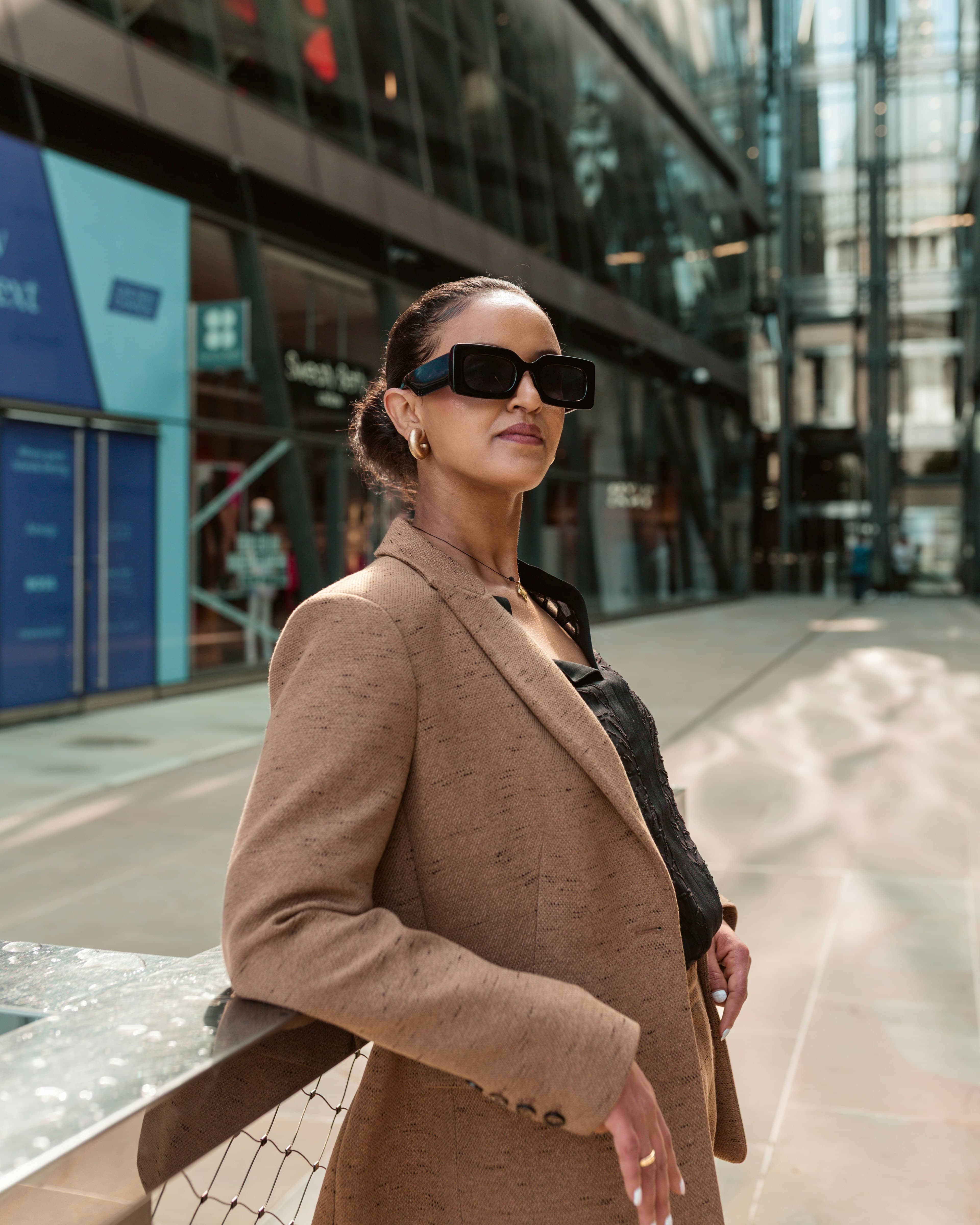 A confident woman in sunglasses on a city street