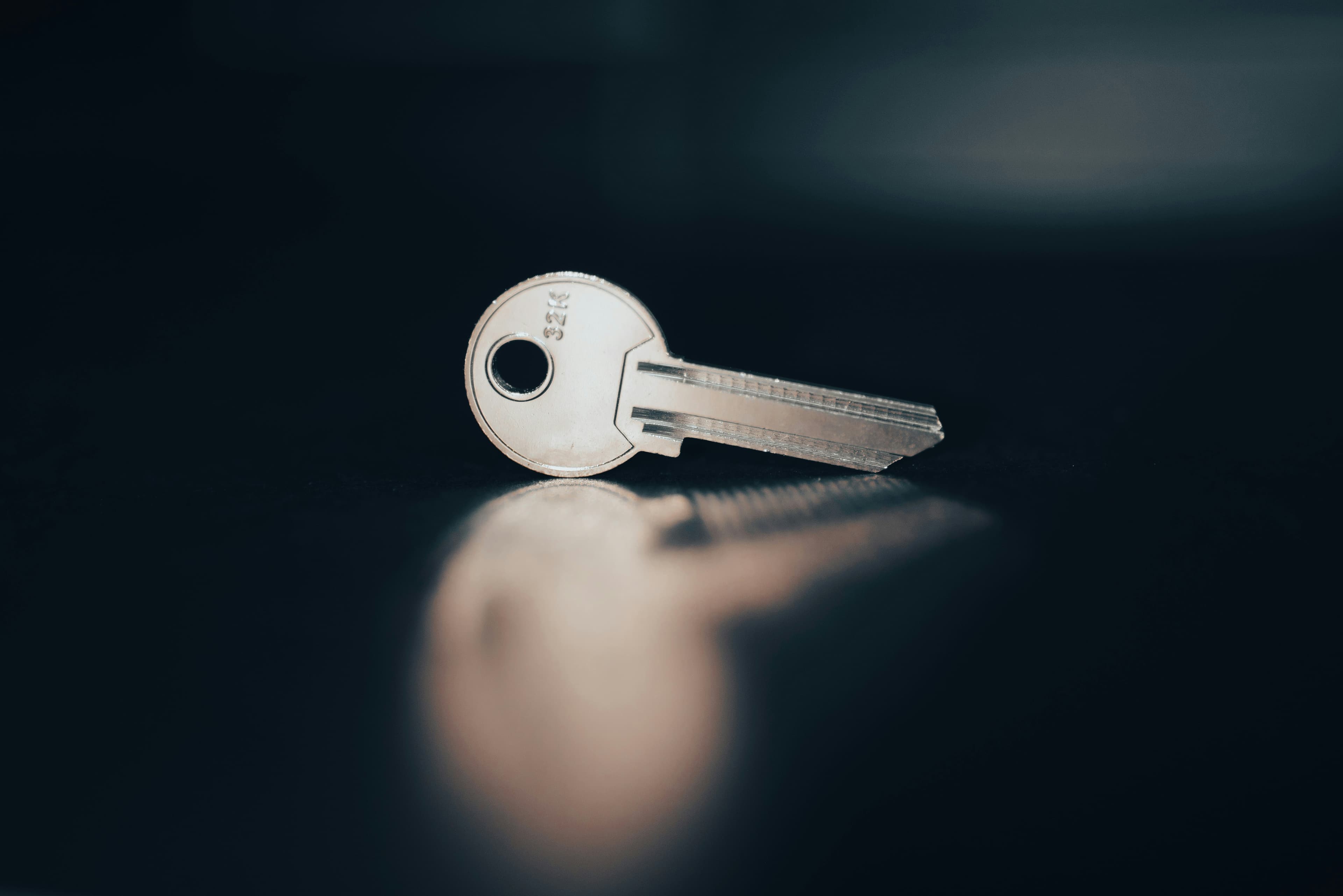 A single key lying on a dark surface